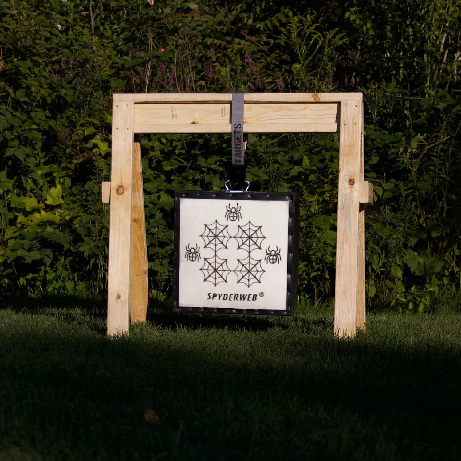 Wooden target stand with a target against a green forest background
